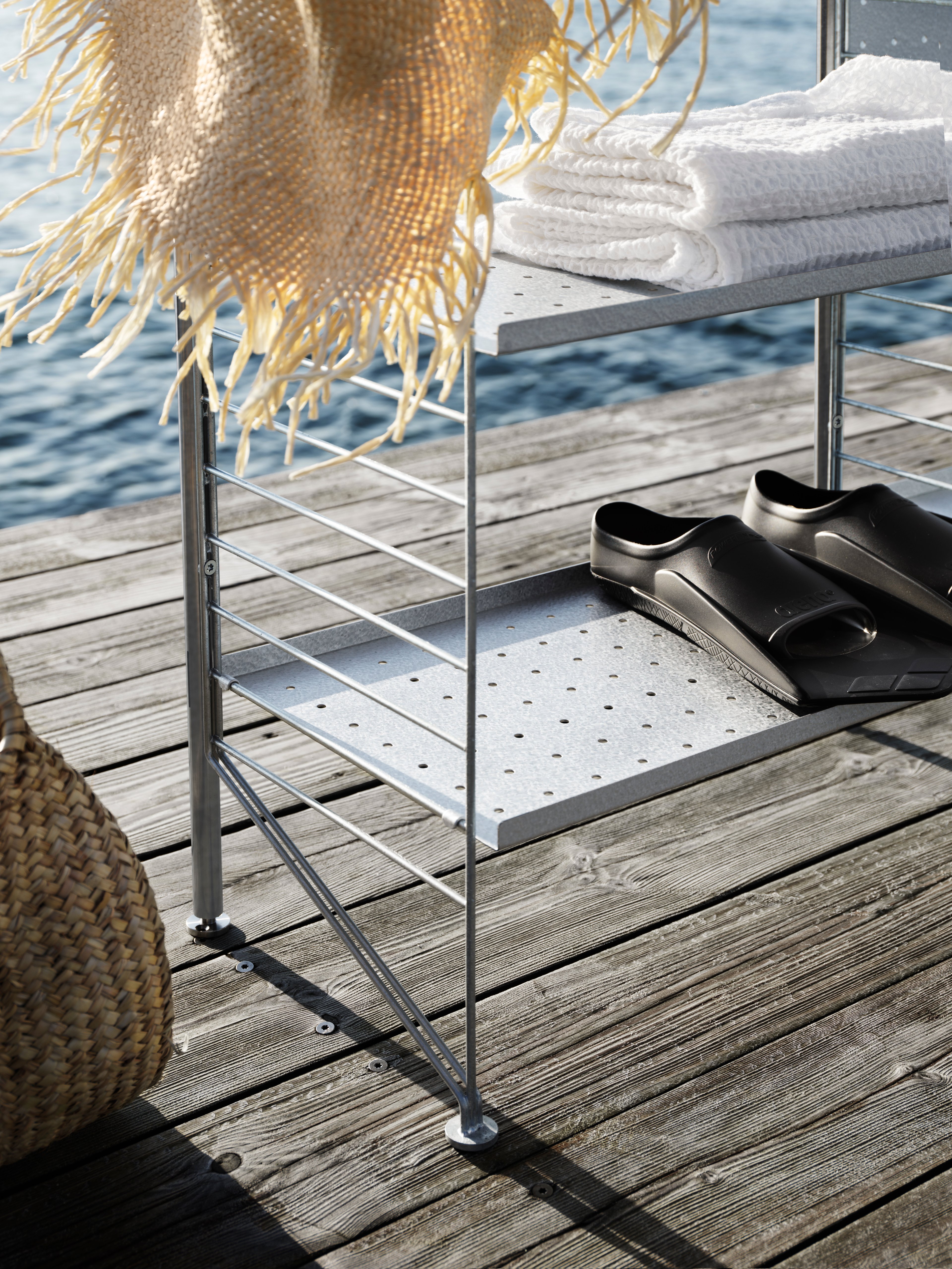 The free standing shelf intended for outdoor use from String® System fits equally well on a smaller balcony as on a larger terrace. The shelf is completely free standing but, if desired, can be secured to the base it is standing on. A complete section of the free standing shelf consists of one back panel, two uprights and two galvanized floor panels with height 85 cm and depth 30 cm. To build additional sections, you need one upright along with one panel for each section. We recommend at least one back panel, preferably placed in the middle, for a free standing shelf consisting of three sections. Add hooks to increase the storage possibilities. One section has the dimensions: width 61 cm and height 87 cm.