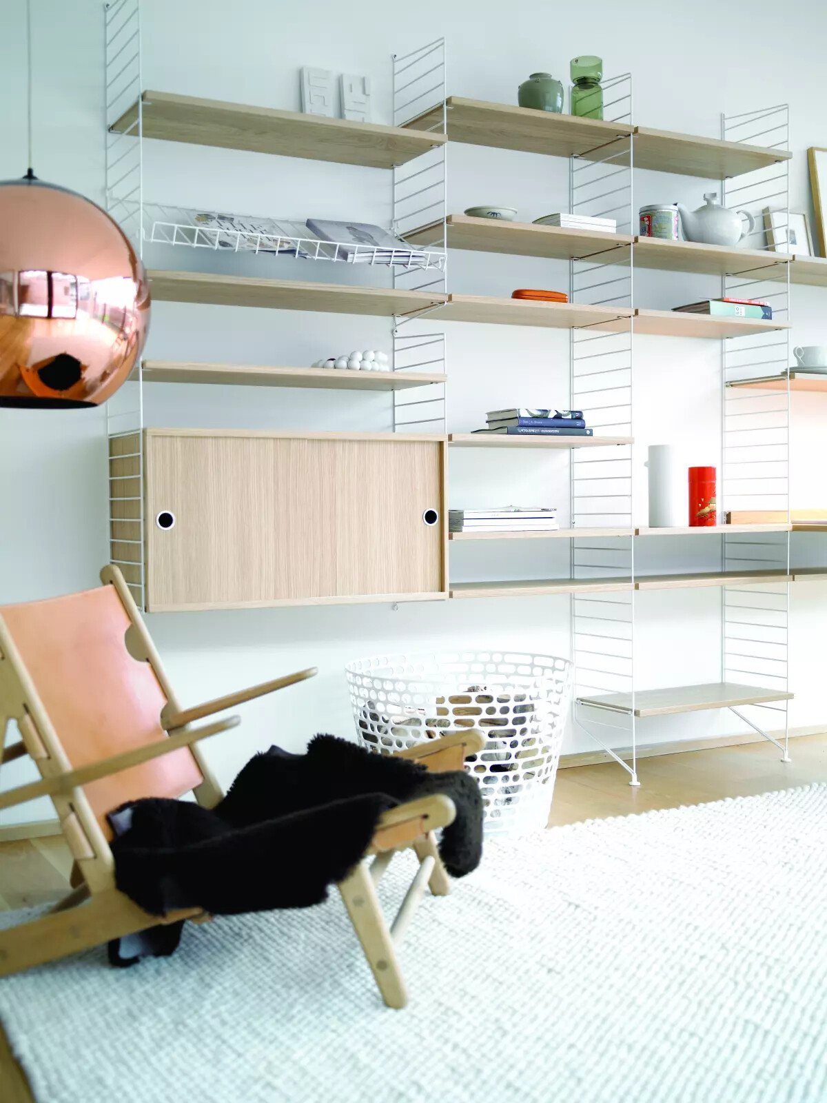 The cabinets with sliding doors are available in one width, 78 cm, along with two depths, 20 and 30 cm. The cabinets fit into all wire and plex panels from String® System. It is visually pleasing to add a bolder element to your shelf, like a cabinet, which also give you a lot of extra storage. The cabinet consists of one divider placed in the middle along with two adjustable inner shelves. The cabinet’s inner dimensions are 4 cm less than the outer dimensions. The cabinets are delivered unassembled.