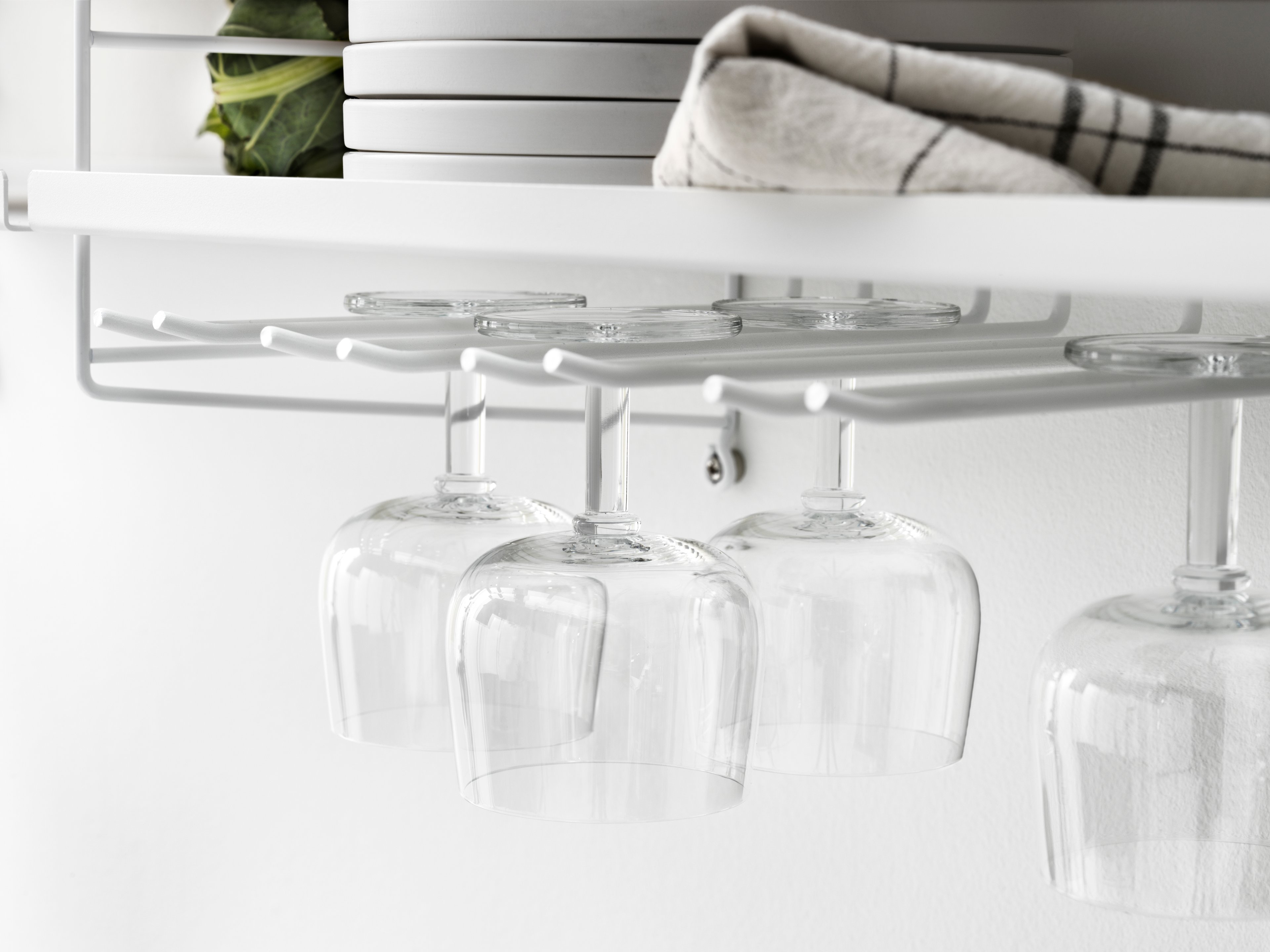 The hanger racks are created to optimize a shelving combination with metal or galvanized shelves. It is the optimal kitchen accessory, and it is available in two different sizes, 20 and 30 cm. Number of wine glasses (diameter of the rim: 7 cm) that fit on 20 cm deep hanger racks are 2-3, and 3-4 on 30 cm deep hanger racks. A 58 cm wide metal shelf can fit up to three hanger racks and a 78 cm wide can fit up to four. Each packaging contains two hanger racks, where each hanger rack has two sets of rails.