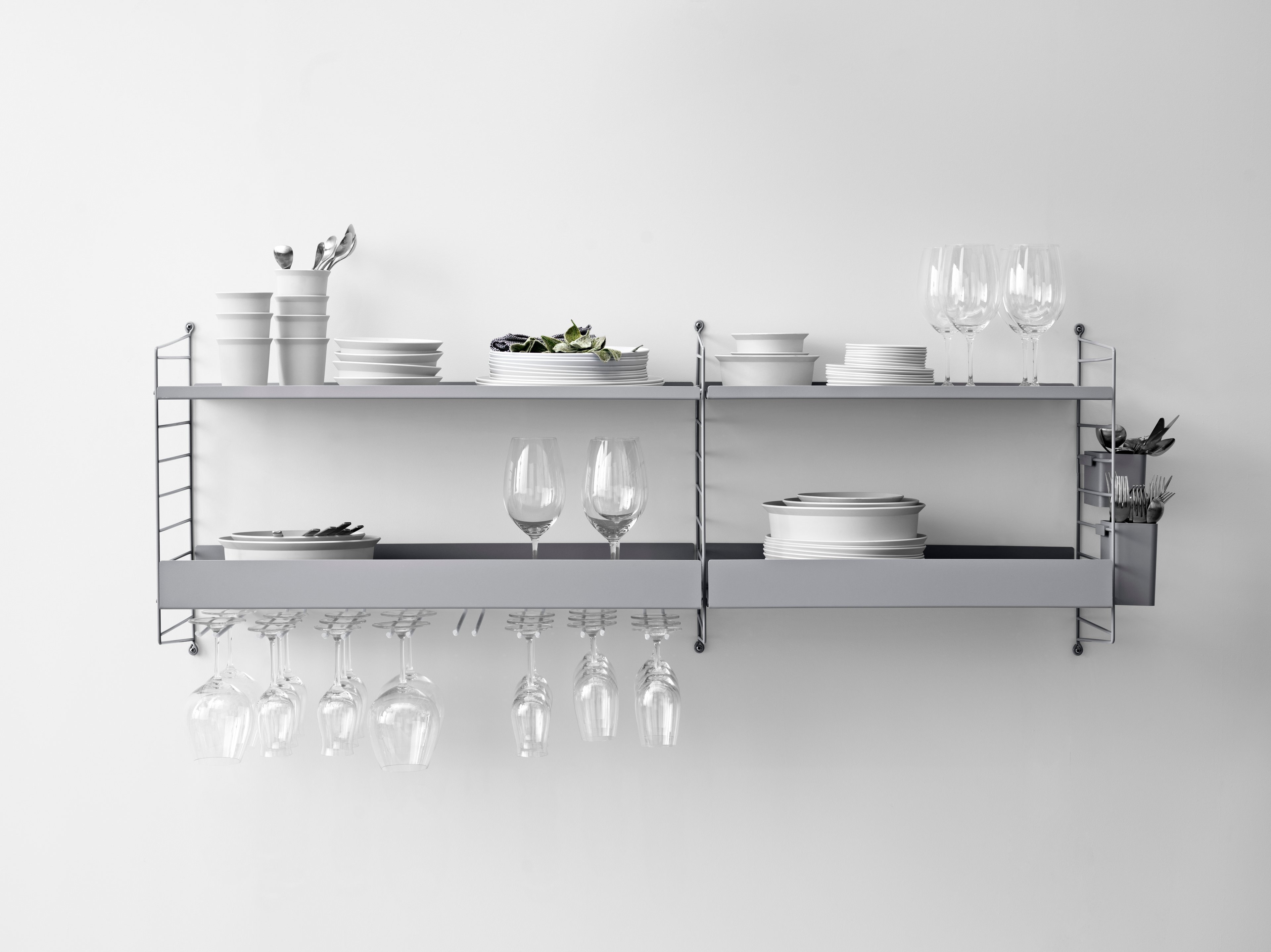 The hanger racks are created to optimize a shelving combination with metal or galvanized shelves. It is the optimal kitchen accessory, and it is available in two different sizes, 20 and 30 cm. Number of wine glasses (diameter of the rim: 7 cm) that fit on 20 cm deep hanger racks are 2-3, and 3-4 on 30 cm deep hanger racks. A 58 cm wide metal shelf can fit up to three hanger racks and a 78 cm wide can fit up to four. Each packaging contains two hanger racks, where each hanger rack has two sets of rails.
