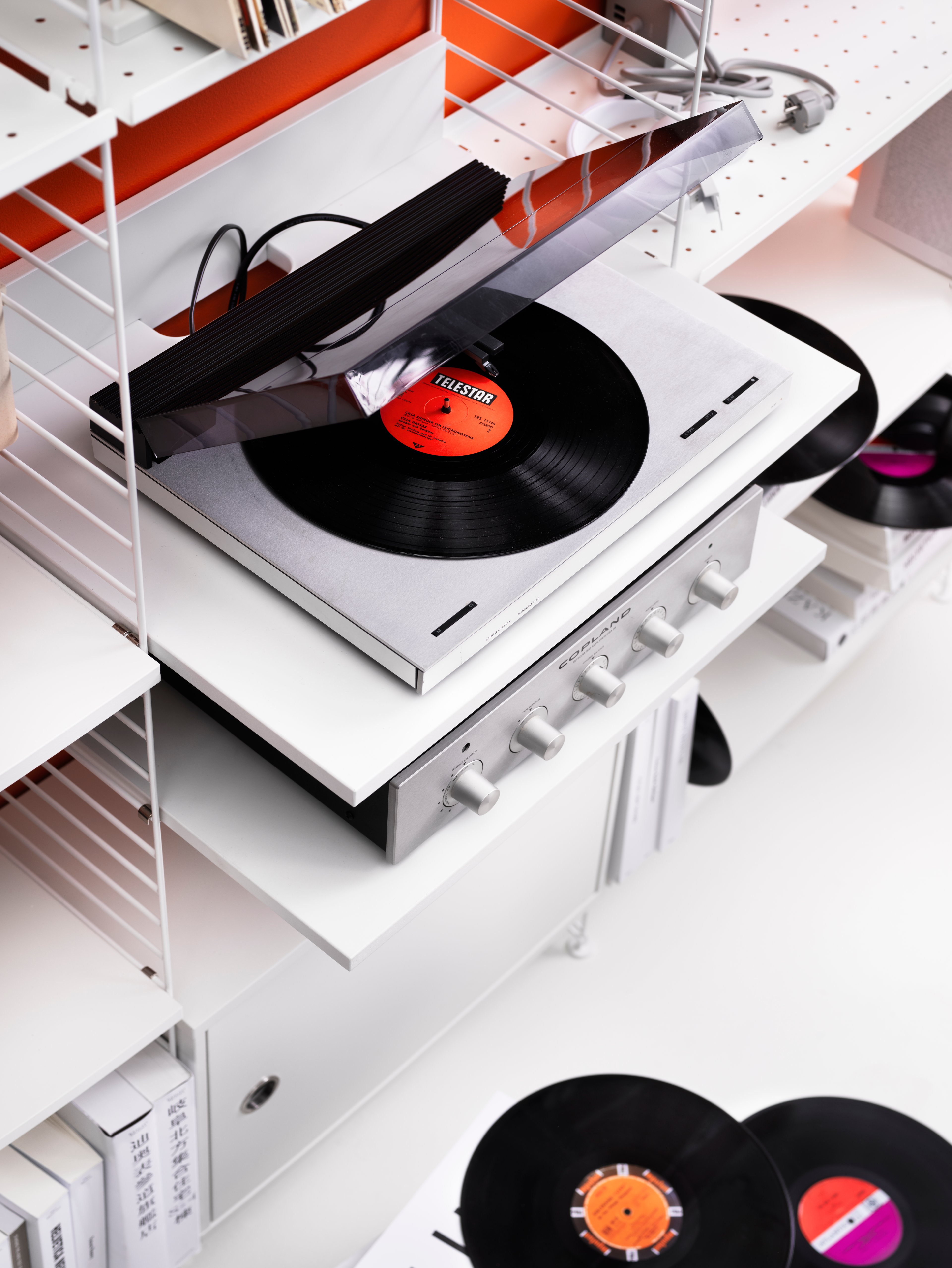 The media shelf is available in one size, b58 x d47 x h10 cm and fits into wire panels from String® System with depth 30 cm. The media shelf is produced to give the vinyl record player a designated spot. The media shelf is designed to help you organize all cords and cables by letting them disappear behind the shelf without the risk of getting pinched between the wall and shelf. The media shelf can easily be turned into a workspace, or why not a drink table. Each packaging contains one media shelf, one ledge to place against the wall to stabilize the media shelf along with brackets.