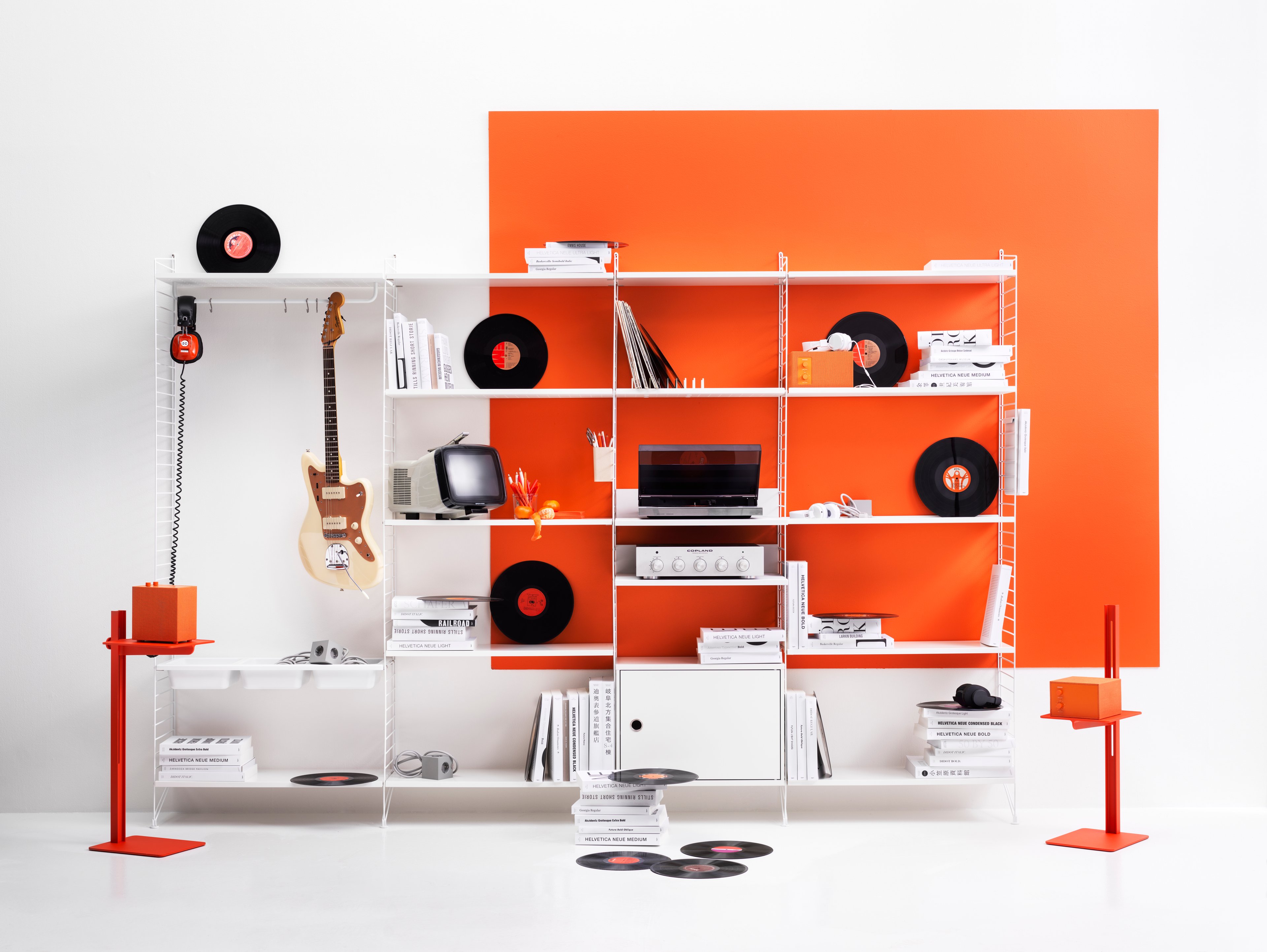 String shelf with floor panels from String System. Panels, shelves, metal shelves with low edge, media shelves and cabinet with swing door. Loads of storage possibilities which makes the combination perfect in both the living room and the home office.