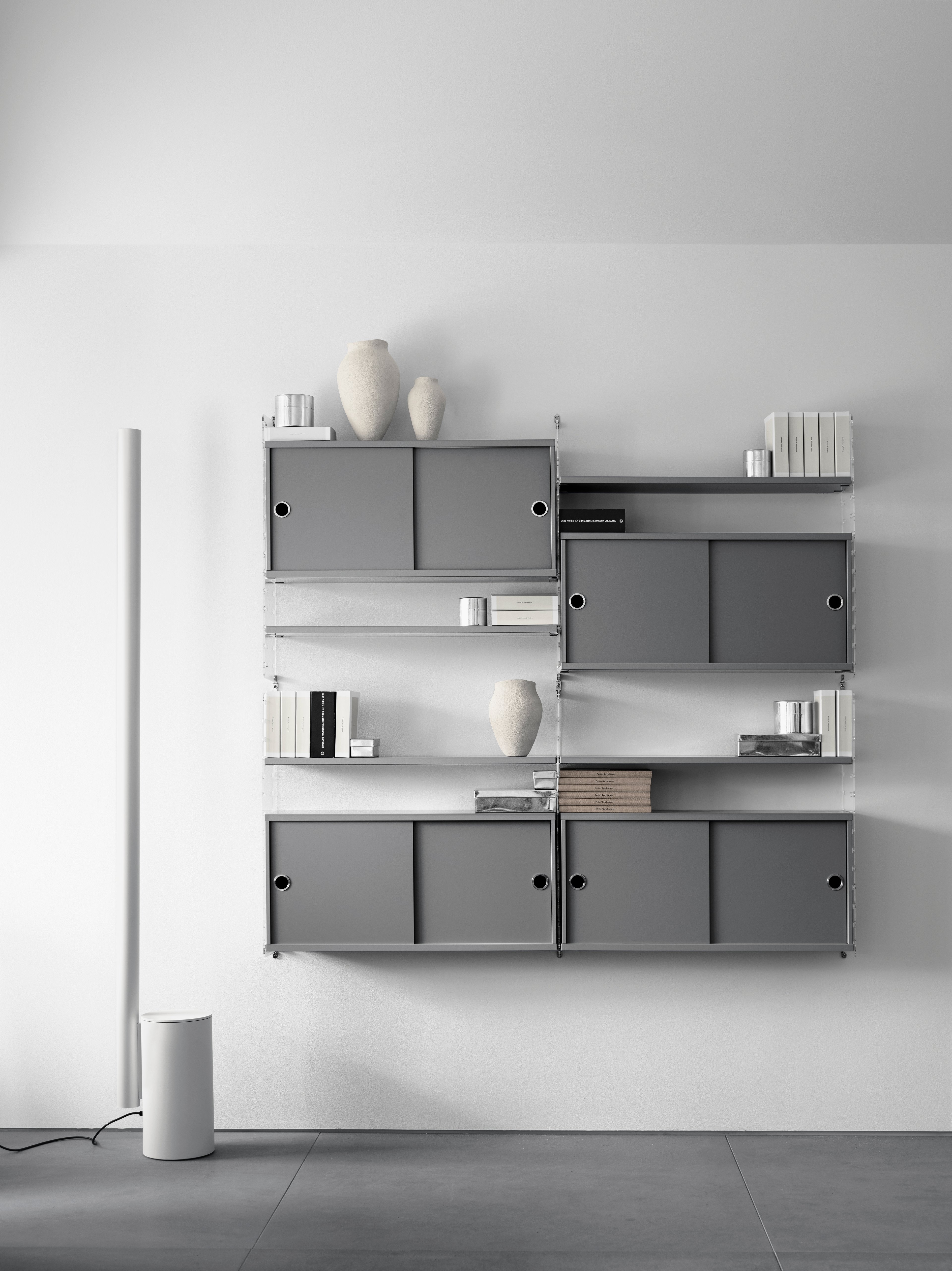 The cabinets with sliding doors are available in one width, 78 cm, along with two depths, 20 and 30 cm. The cabinets fit into all wire and plex panels from String® System. It is visually pleasing to add a bolder element to your shelf, like a cabinet, which also give you a lot of extra storage. The cabinet consists of one divider placed in the middle along with two adjustable inner shelves. The cabinet’s inner dimensions are 4 cm less than the outer dimensions. The cabinets are delivered unassembled.