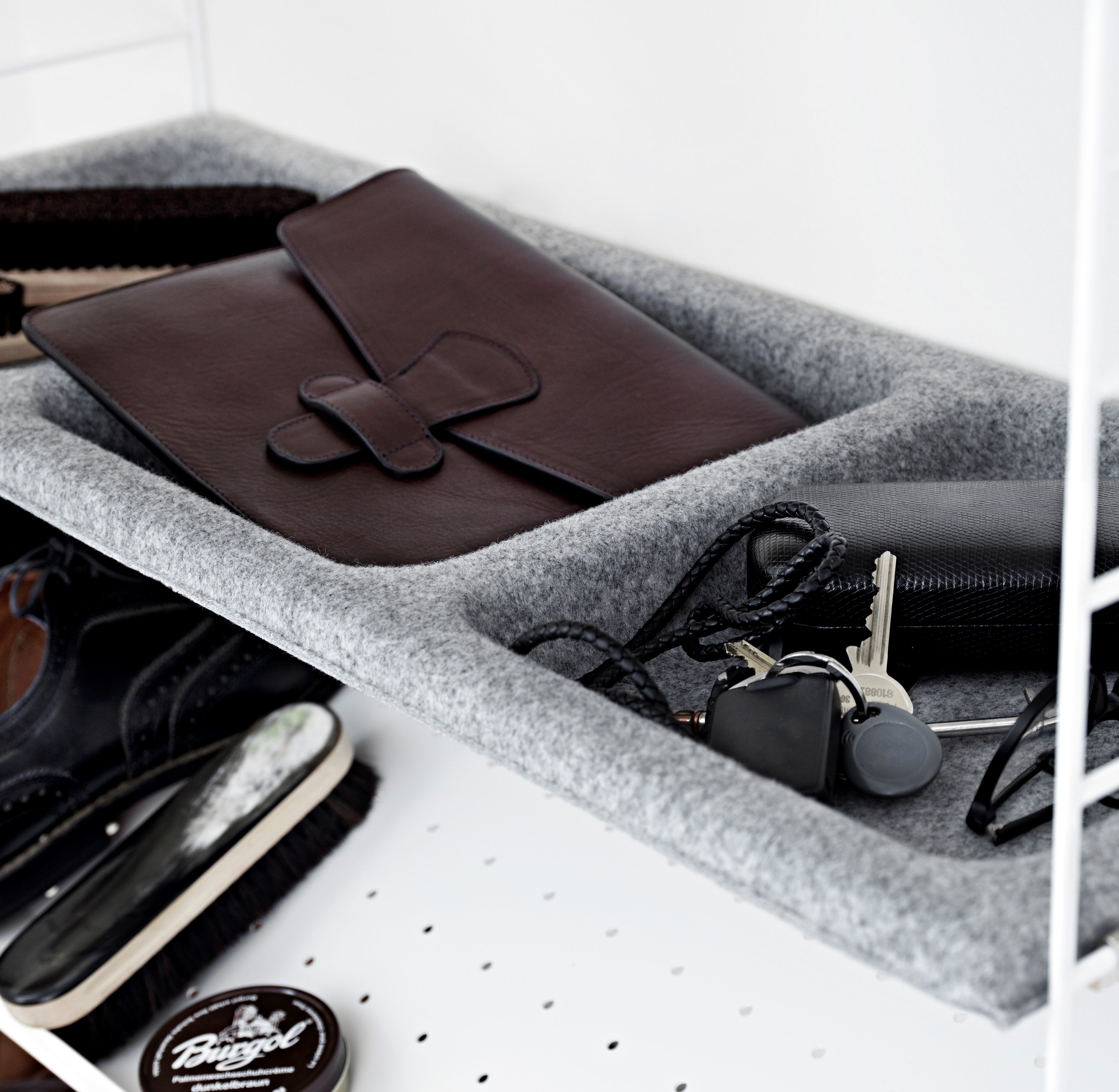 The bowl shelf in felt is available in one width, 78 cm, and one depth, 30 cm. The bowl shelf fits into all 30 cm deep wire and plex panels from String® System. By adding a bowl shelf in felt to your hallway combination, you instantly add a given spot for keys, gloves, and such. The internal dimensions for each bowl (three in total) are: w20 x d22 x h4.5 cm. Each packaging contains one bowl shelf in felt and a frame along with brackets. The colours options are beige, light grey and anthracite.