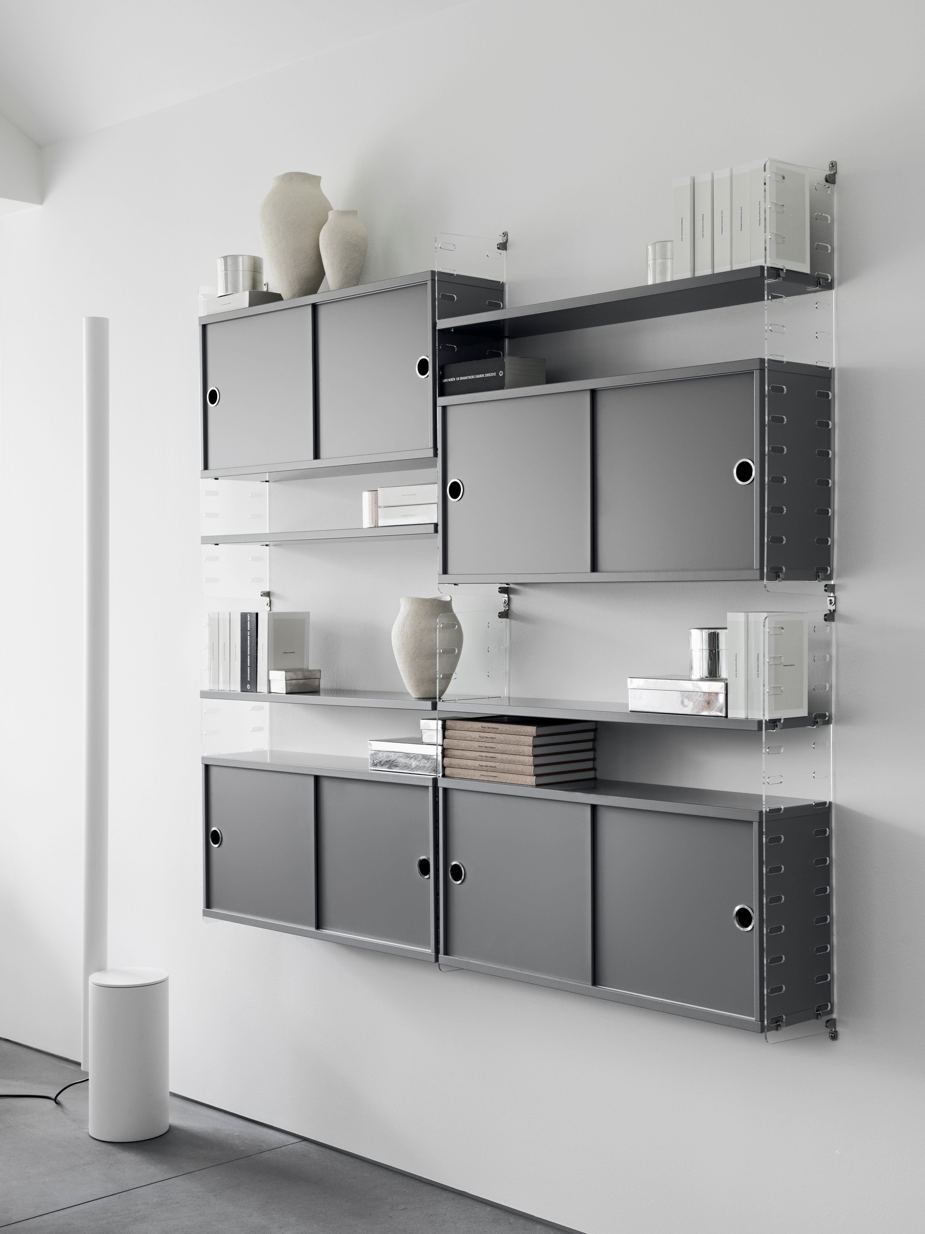The cabinets with sliding doors are available in one width, 78 cm, along with two depths, 20 and 30 cm. The cabinets fit into all wire and plex panels from String® System. It is visually pleasing to add a bolder element to your shelf, like a cabinet, which also give you a lot of extra storage. The cabinet consists of one divider placed in the middle along with two adjustable inner shelves. The cabinet’s inner dimensions are 4 cm less than the outer dimensions. The cabinets are delivered unassembled.